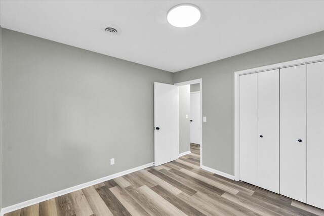 unfurnished bedroom featuring a closet and light wood-type flooring