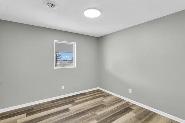 empty room featuring hardwood / wood-style flooring and a textured ceiling
