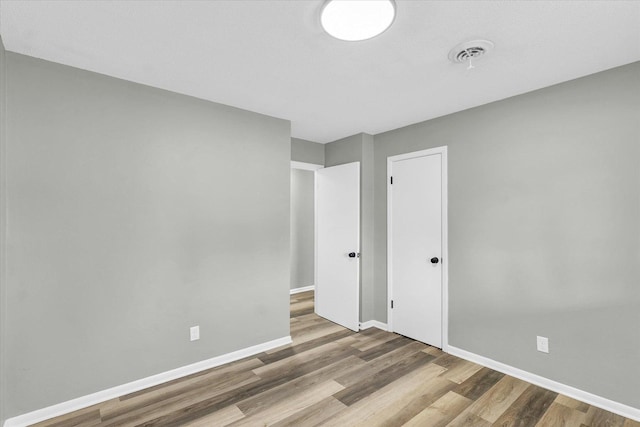 unfurnished bedroom featuring wood-type flooring and a closet