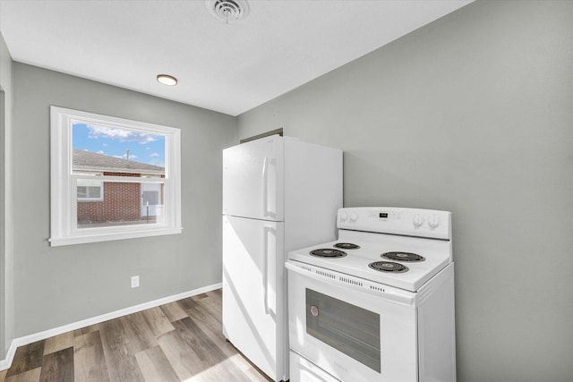 kitchen with white appliances and light hardwood / wood-style floors