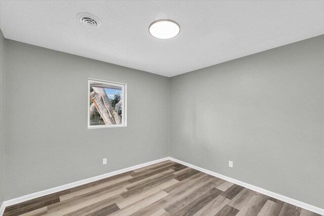 unfurnished room with wood-type flooring