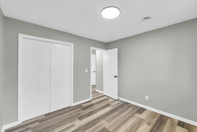 unfurnished bedroom featuring a closet and light wood-type flooring