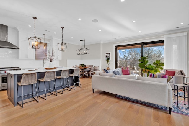 living room with light hardwood / wood-style flooring and ornamental molding