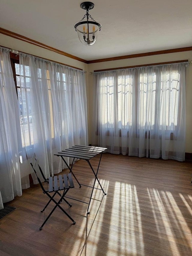 unfurnished dining area featuring light hardwood / wood-style flooring, crown molding, and plenty of natural light