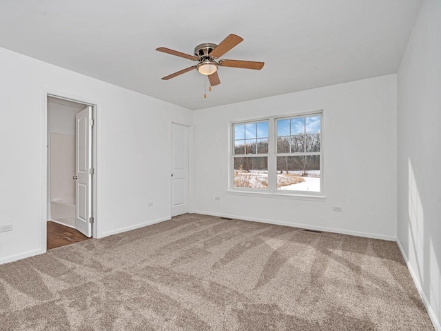 carpeted spare room featuring ceiling fan