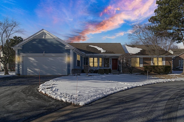 single story home with aphalt driveway and an attached garage