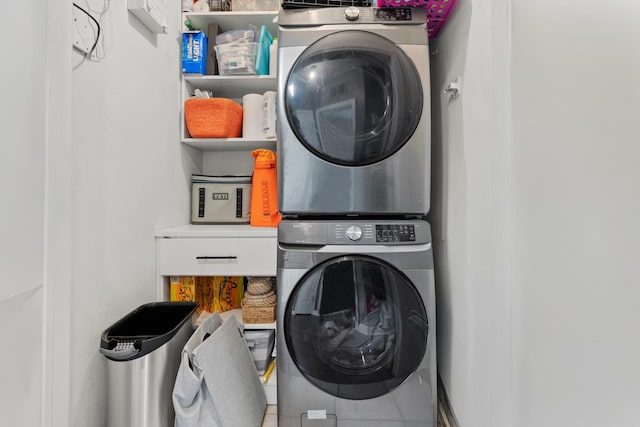 washroom featuring stacked washer and clothes dryer