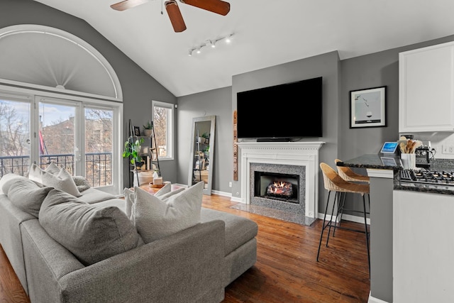 living room featuring lofted ceiling, dark wood-type flooring, and ceiling fan