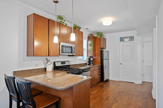 kitchen with pendant lighting, a breakfast bar area, stainless steel appliances, dark hardwood / wood-style floors, and kitchen peninsula