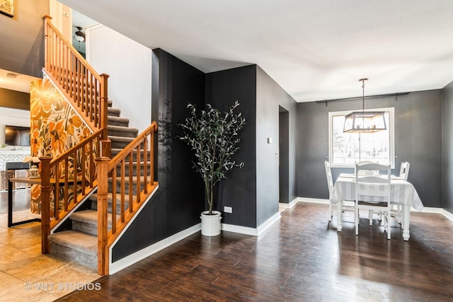 dining area featuring baseboards, stairway, and wood finished floors