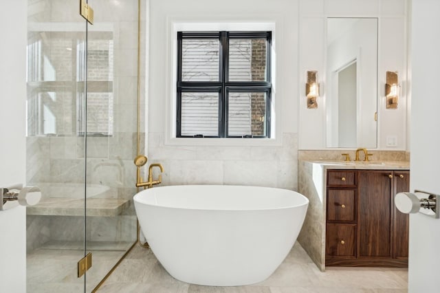 bathroom with shower with separate bathtub, tile walls, and vanity