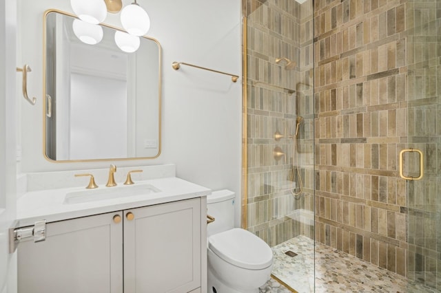 bathroom featuring vanity, toilet, and a shower with shower door