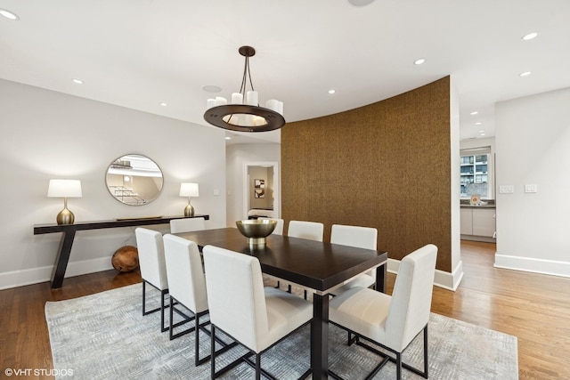 dining area with recessed lighting, an inviting chandelier, baseboards, and wood finished floors