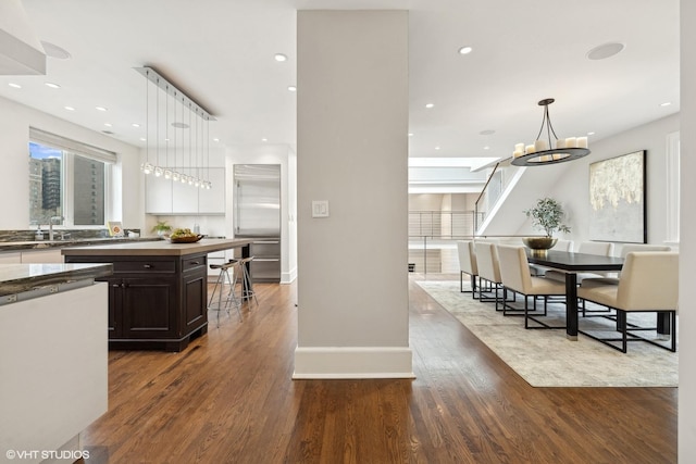 kitchen featuring recessed lighting, pendant lighting, dark wood finished floors, and dark brown cabinets