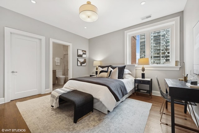 bedroom with recessed lighting, visible vents, connected bathroom, wood finished floors, and baseboards