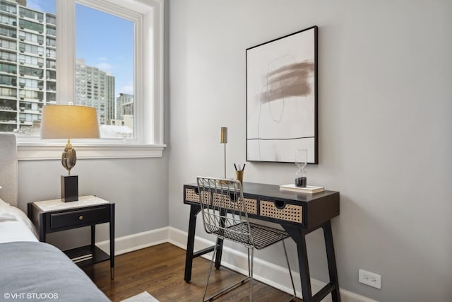 bedroom featuring a city view, wood finished floors, and baseboards