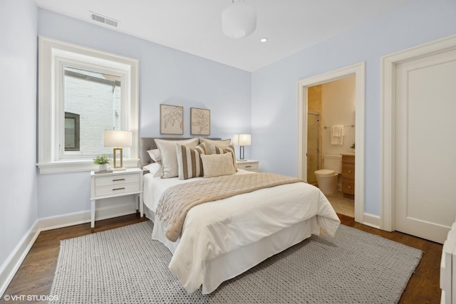 bedroom with visible vents, ensuite bathroom, baseboards, and wood finished floors