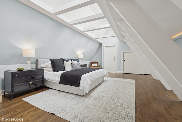 bedroom featuring vaulted ceiling with beams and wood finished floors