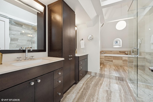 bathroom with tiled tub, two vanities, a sink, and a shower stall