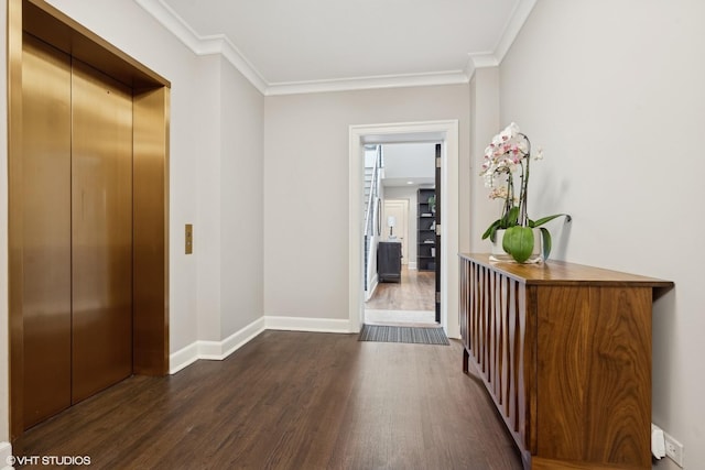 corridor with crown molding, elevator, dark wood finished floors, and baseboards