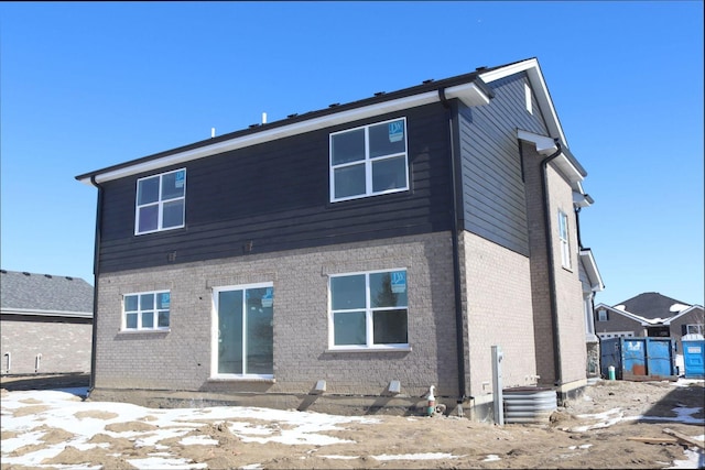 rear view of property with brick siding