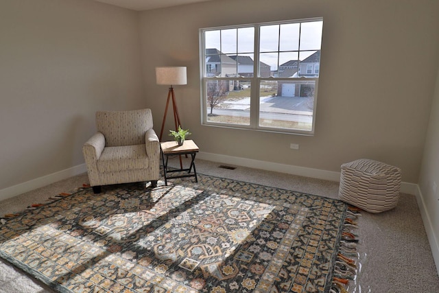 sitting room with visible vents, baseboards, and carpet flooring