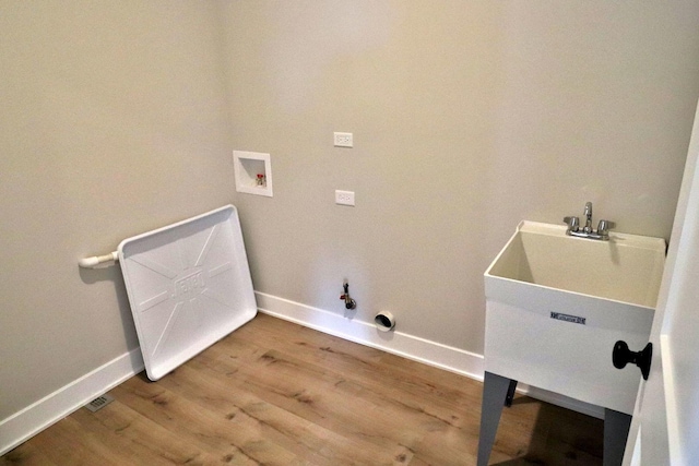 washroom featuring laundry area, hookup for a washing machine, wood finished floors, and baseboards