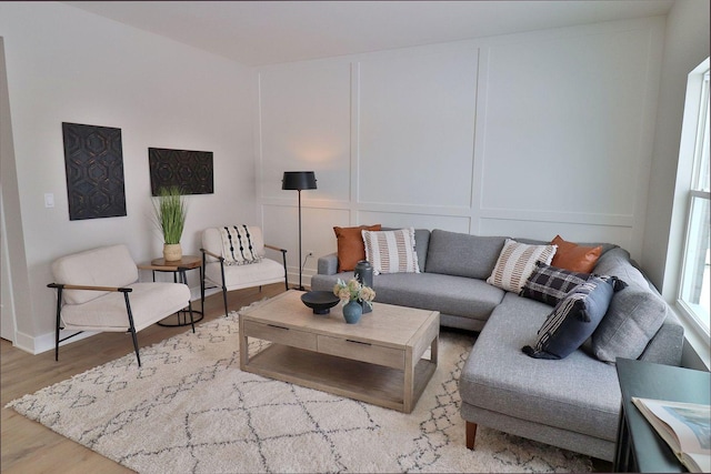 living area with a decorative wall and wood finished floors