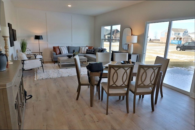 dining room with a wealth of natural light, a decorative wall, recessed lighting, and light wood-type flooring