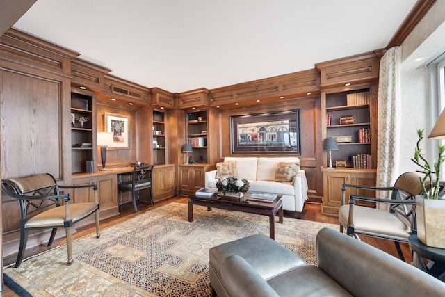 interior space featuring built in shelves, ornamental molding, and light wood-type flooring