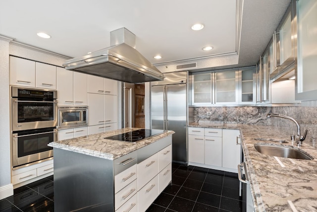 kitchen featuring white cabinetry, sink, island exhaust hood, a center island, and built in appliances