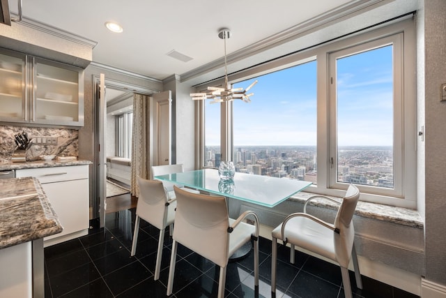 tiled dining room with a notable chandelier and ornamental molding