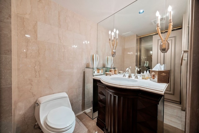 bathroom with vanity, tile patterned flooring, tile walls, and toilet