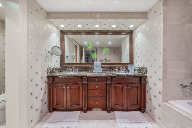 bathroom featuring toilet, tile patterned floors, vanity, and tiled bath