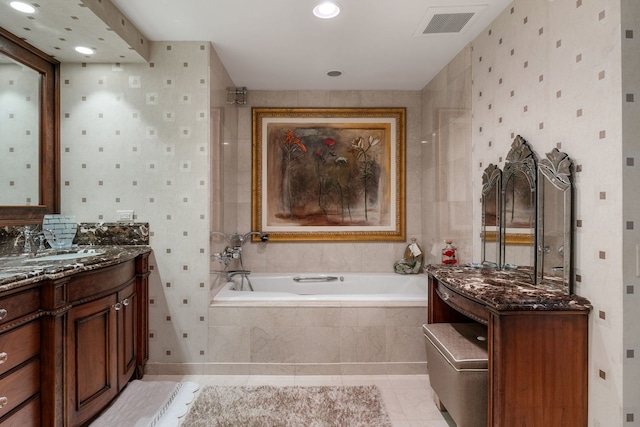 bathroom featuring vanity, tiled tub, and tile patterned floors