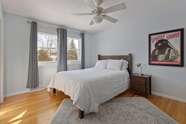 bedroom featuring baseboards, visible vents, ceiling fan, and wood finished floors