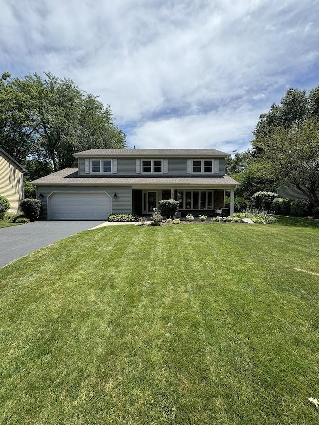 view of front of home featuring driveway, an attached garage, and a front lawn