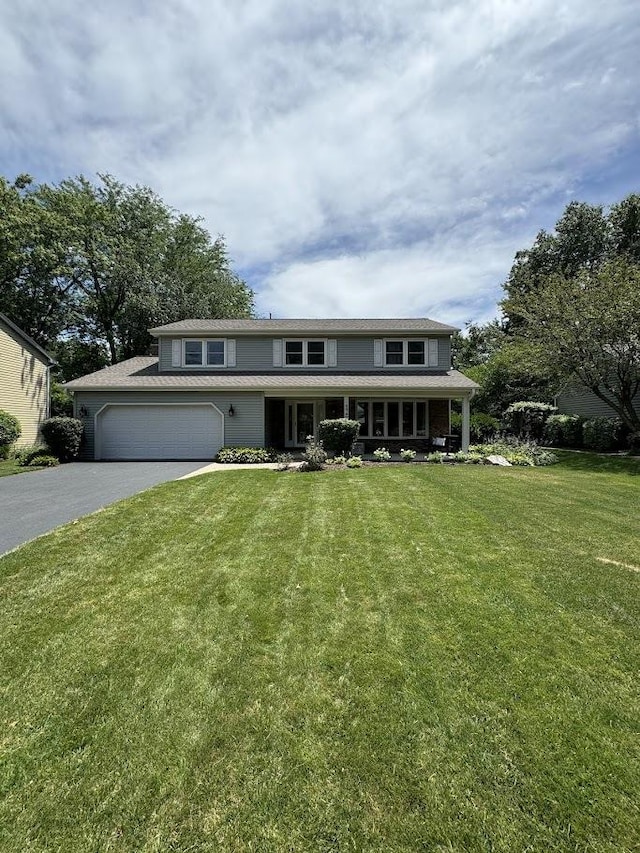 view of front of property featuring aphalt driveway, a front lawn, and an attached garage