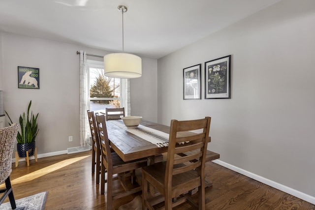 dining area featuring dark wood-style flooring, visible vents, and baseboards