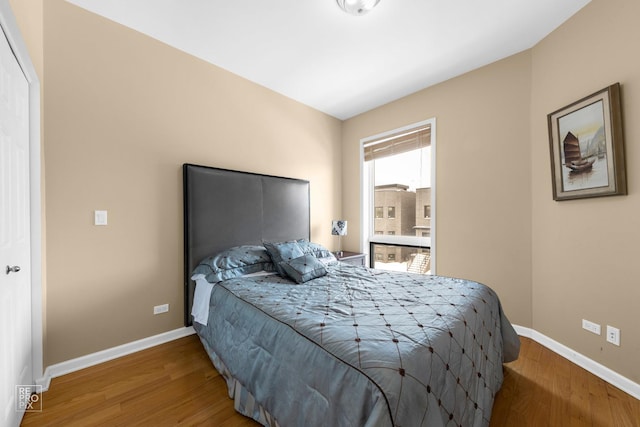 bedroom with baseboards and wood finished floors