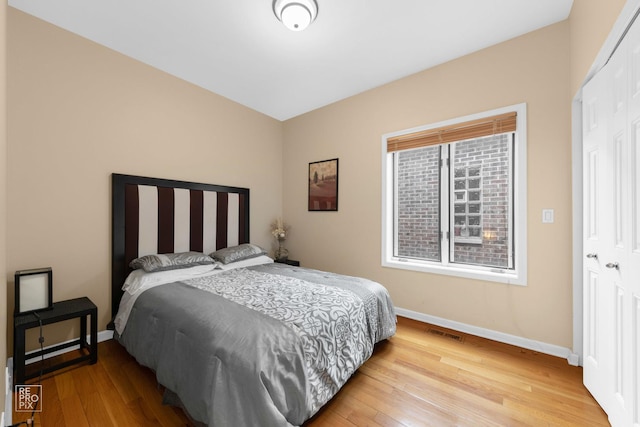 bedroom featuring light wood-style floors, baseboards, and visible vents