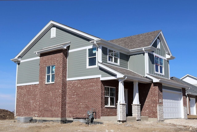 view of home's exterior featuring a garage, brick siding, and roof with shingles