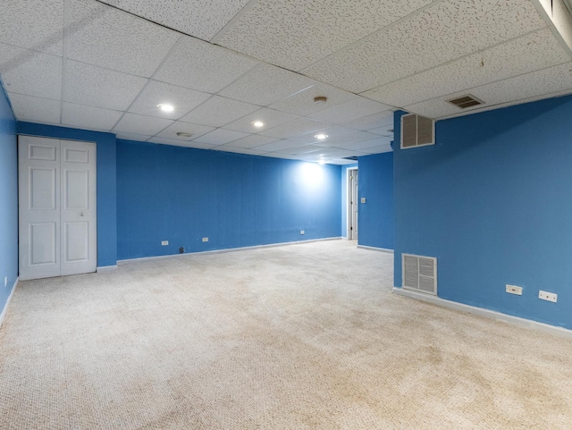 basement featuring carpet flooring and a drop ceiling