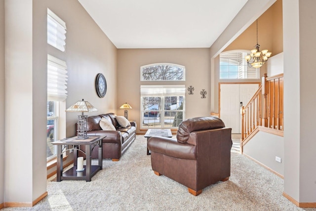 living room featuring a notable chandelier, carpet floors, and a towering ceiling