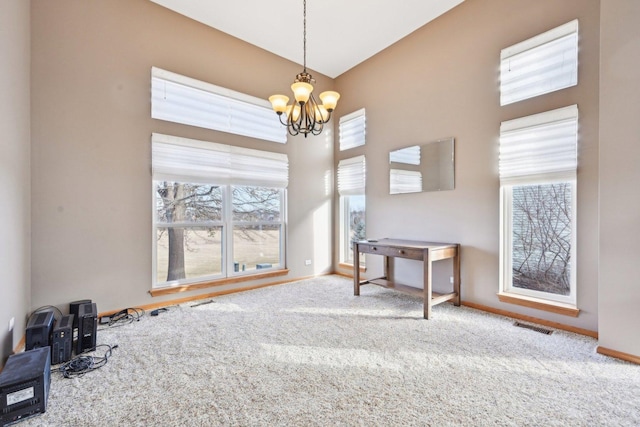 interior space with a healthy amount of sunlight, an inviting chandelier, and carpet floors