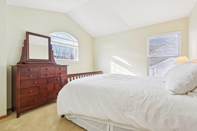 bedroom featuring light carpet and vaulted ceiling