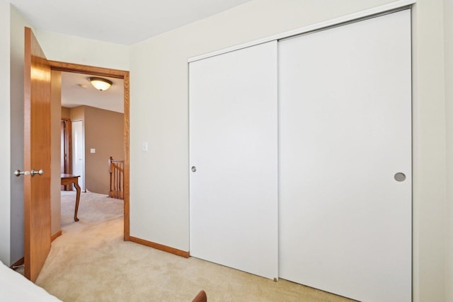 bedroom with light carpet and a closet