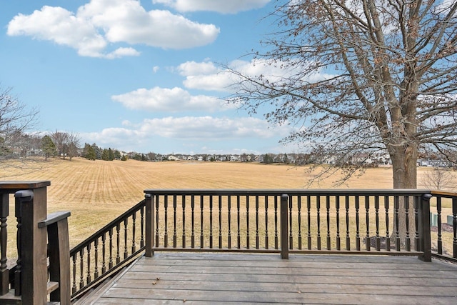 wooden deck with a rural view and a yard