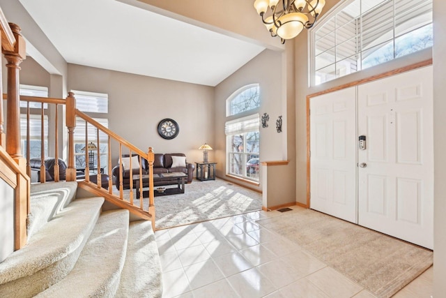 tiled entrance foyer with a high ceiling and a notable chandelier