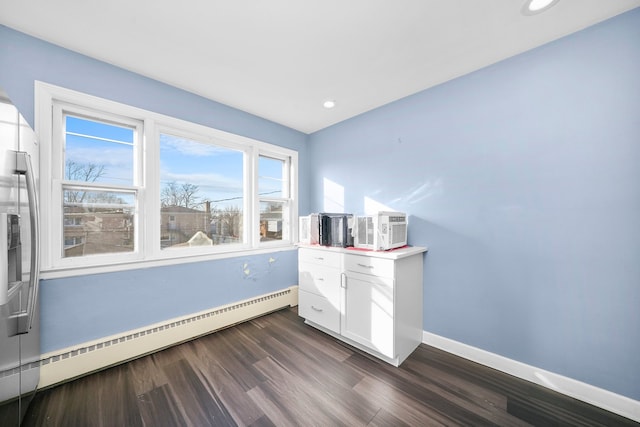 interior space with dark hardwood / wood-style floors and baseboard heating